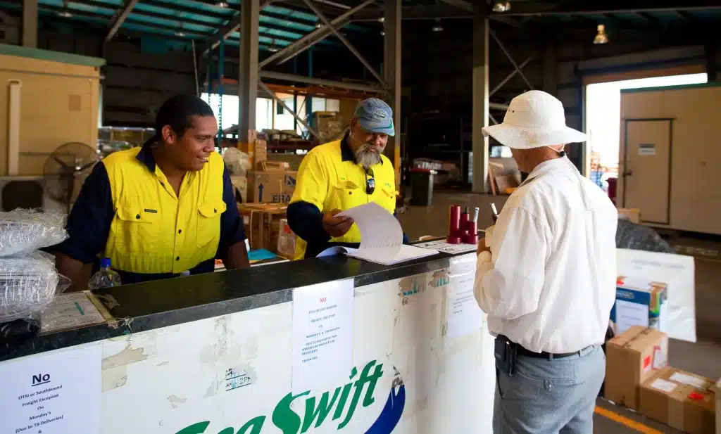 Sea Swift Crew Members assisting customer with paperwork at front counter.